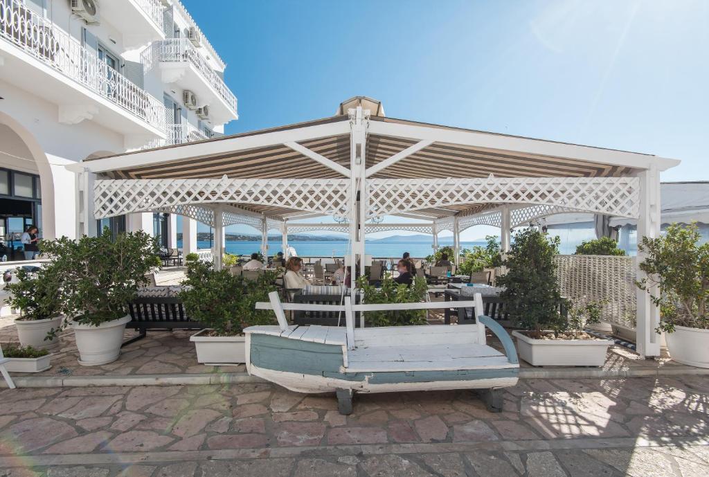 a pergola with people sitting at a table at Klimis Hotel in Spetses