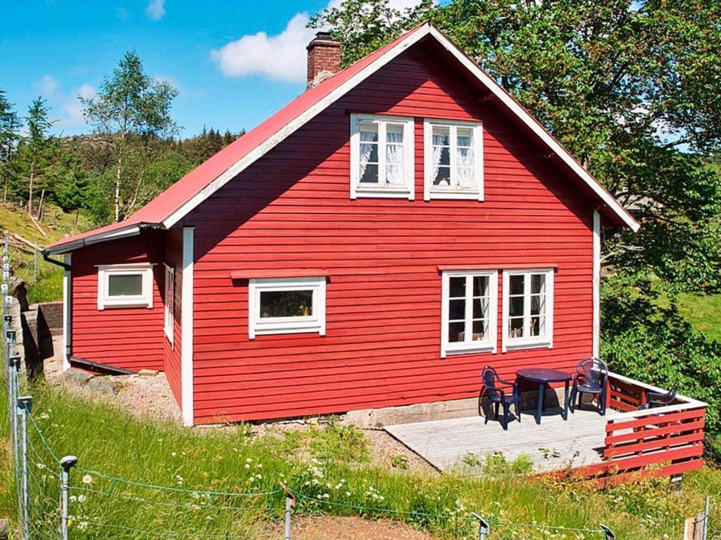 a red house with two chairs in front of it at Holiday home bremnes II in Bremnes