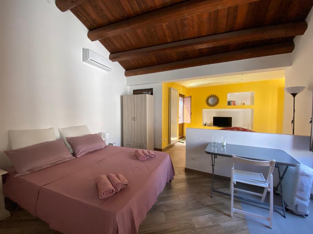 ein Schlafzimmer mit einem Bett und einem Tisch sowie ein Esszimmer in der Unterkunft Monolocale Sant'Andrea in Palermo