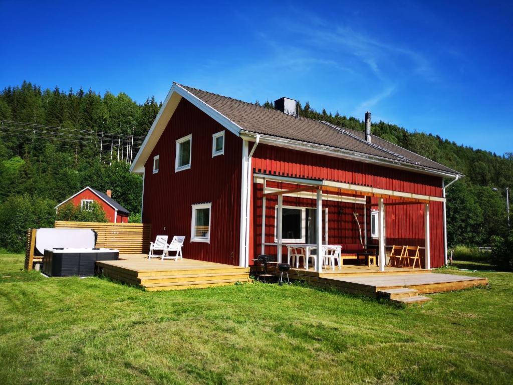 a red barn with a deck and chairs on it at Lilov in Sysslebäck