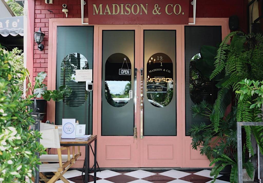 uma porta rosa de uma loja madison e co em Madison Hotel em Nakhon Si Thammarat