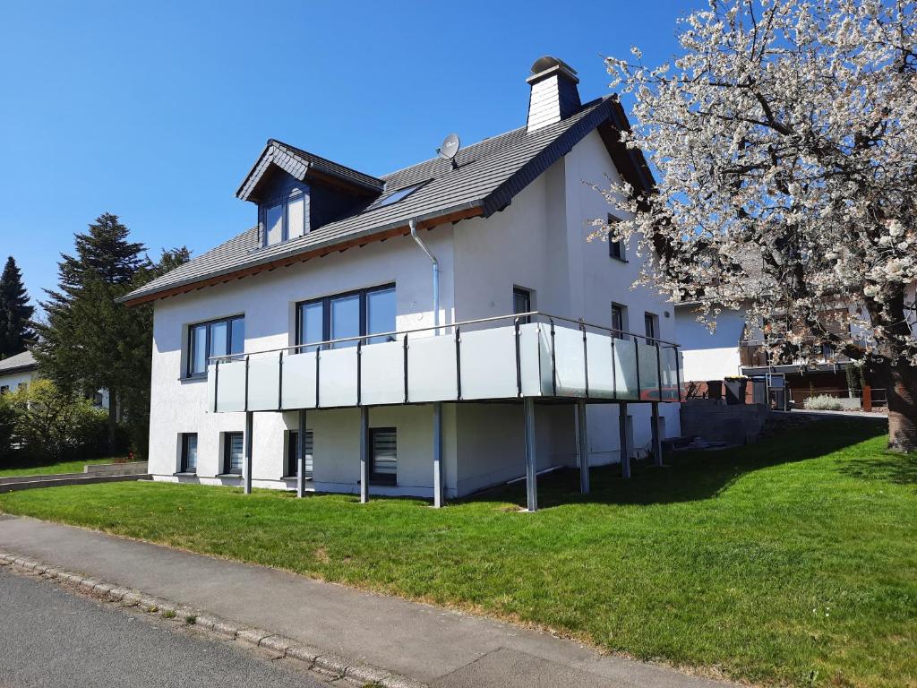 een wit huis met een balkon aan de zijkant bij Ferienwohnung Adams in Faid