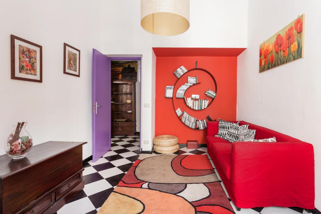 a living room with a red couch and a checkered floor at Casa vacanze a pochi passi da Villa Bellini in Catania