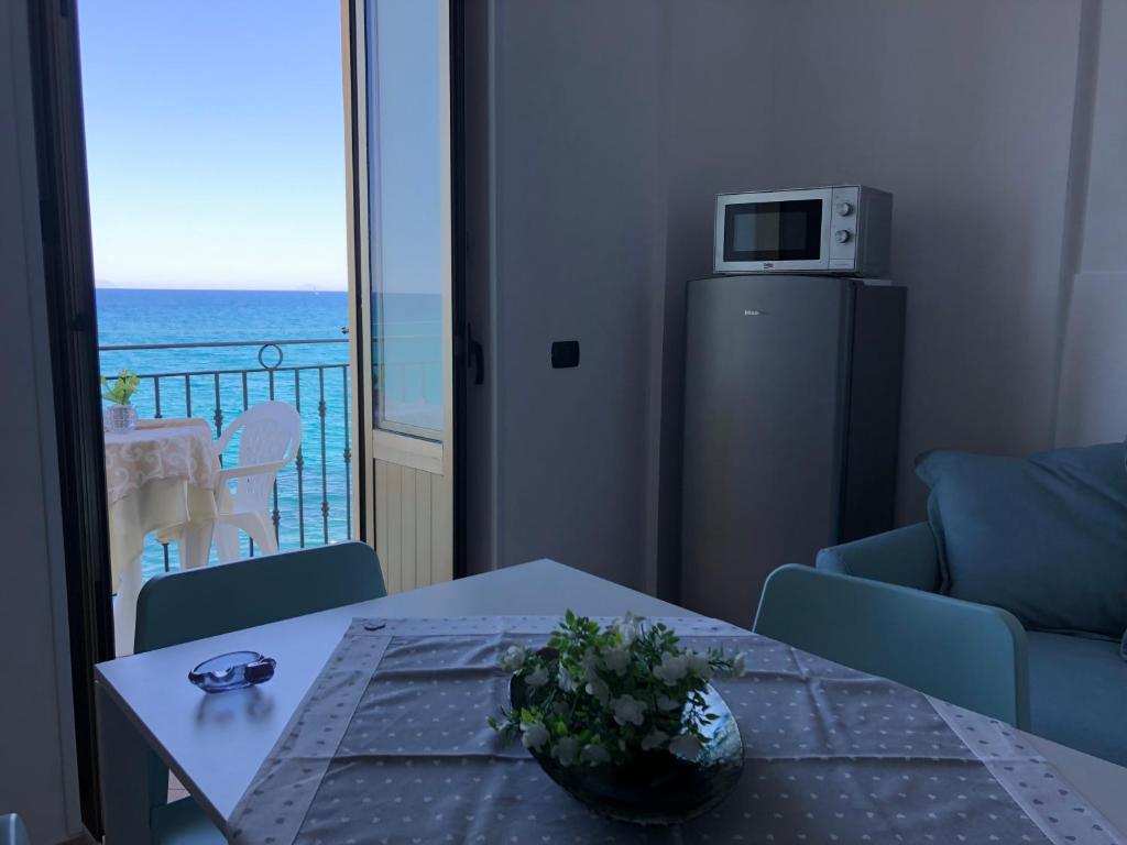 a living room with a table and a view of the ocean at La Casa Sulla Scogliera in Cefalù