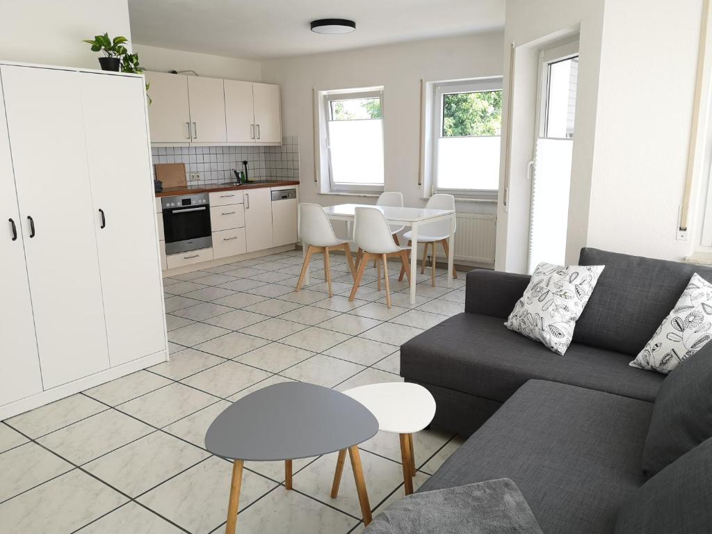 a living room with a couch and a table at Familienfreundliche Ferienwohnung mit Wohlfühlbalkon und kostenlosem Parkplatz nahe Messe und Bodensee in Meckenbeuren