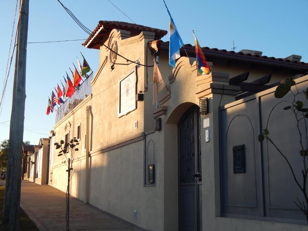 a building with flags on the side of it at Raices del Carolino - Suites de Altagracia in Alta Gracia