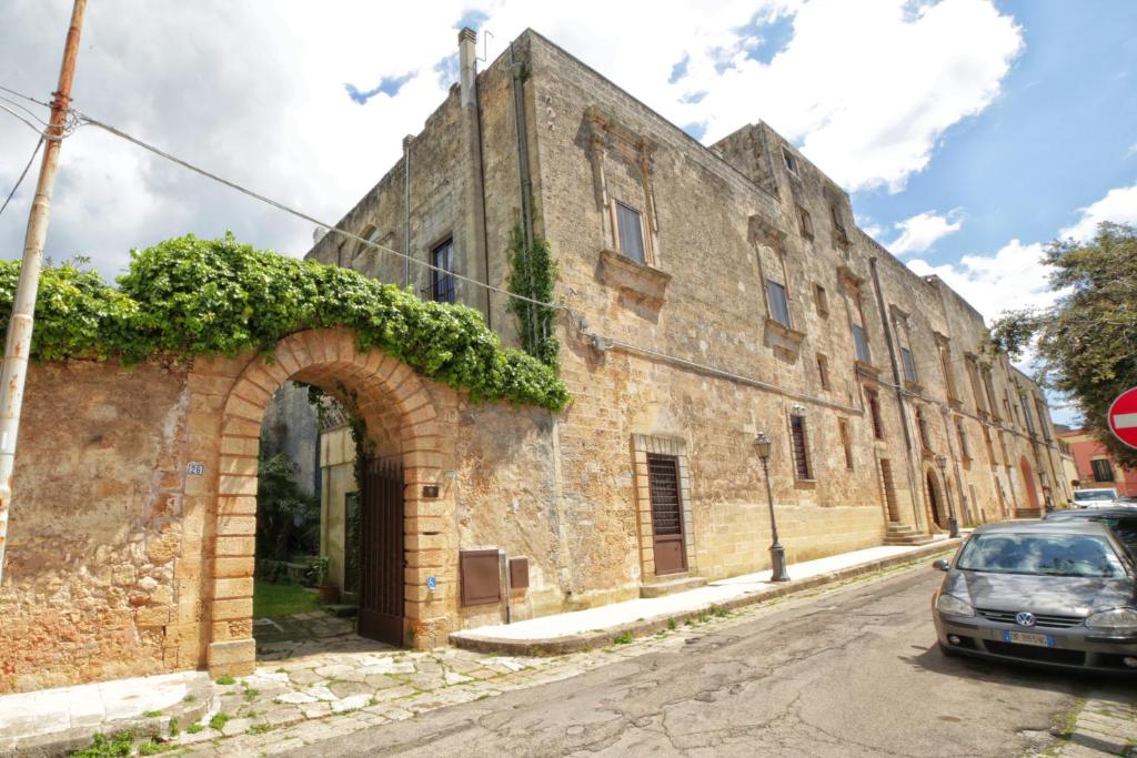 アレッサーノにあるPalazzo Ducale Sangiovanniの通路のアーチ道のある古い石造りの建物