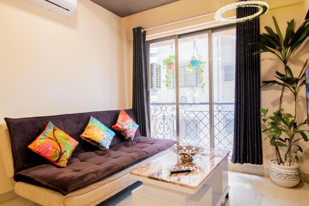 a living room with a couch and a window at OSI Apartments Carter's Road Bandra West in Mumbai