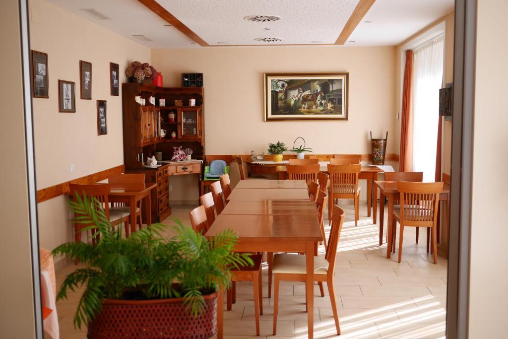 une salle à manger avec des tables et des chaises en bois dans l'établissement Auberge Aux Deux Sapins, à Montricher