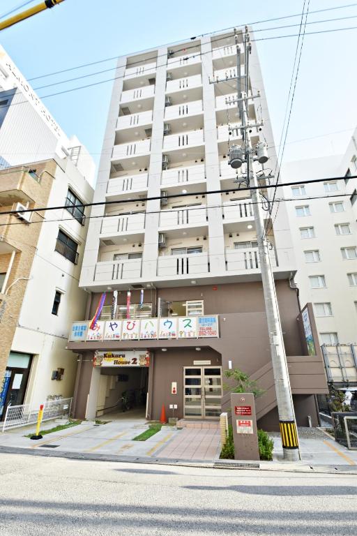 a large white building on the corner of a street at Daruma apartment 403 in Naha