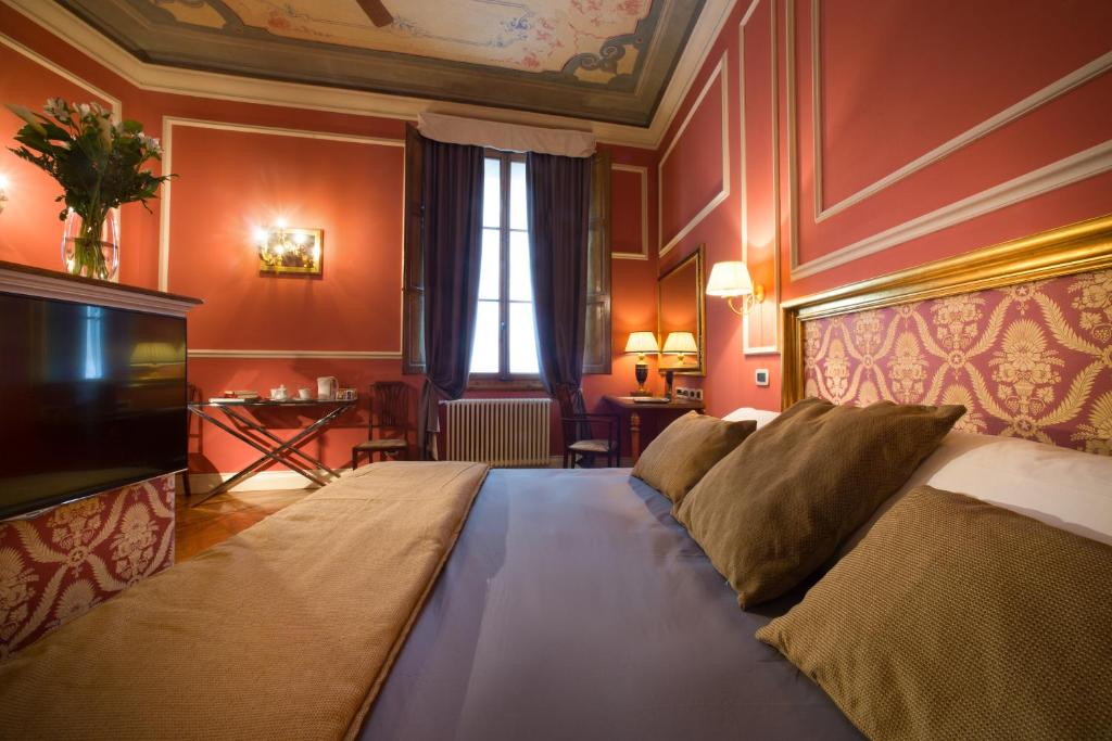 a bedroom with a large bed and a television at Boutique B&B Torre de' Conti in Florence