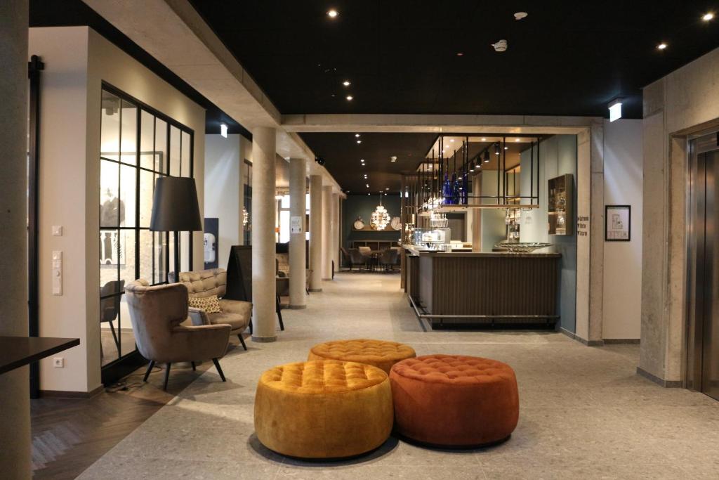 a lobby with two ottomans and two stools at Hotel Zeitgeist in Warburg