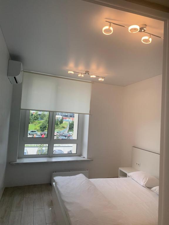 a bedroom with a white bed and a window at New 3 rooms apartment near the metro station in Kyiv