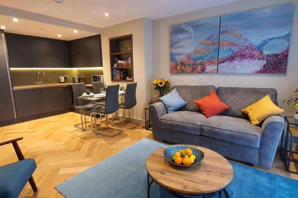 uma sala de estar com um sofá e uma mesa em Luxury One Bedroom Apartment Within the City Walls em York