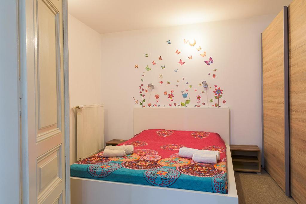 a small bedroom with a bed with a red bedspread at Center Walking Apartment and Room in Bucharest