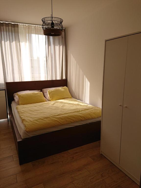 um quarto com uma cama com lençóis amarelos e uma janela em Warsaw Center's Apartment em Varsóvia