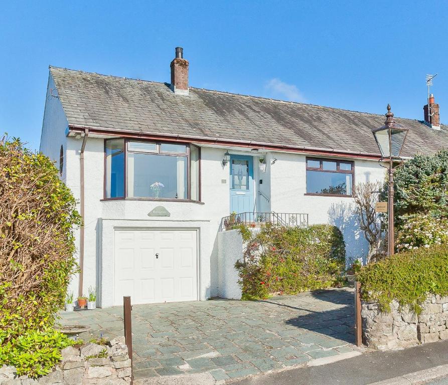 a white house with a white garage at Kents Bank Holiday - Pet Friendly with Bay Views in Grange Over Sands