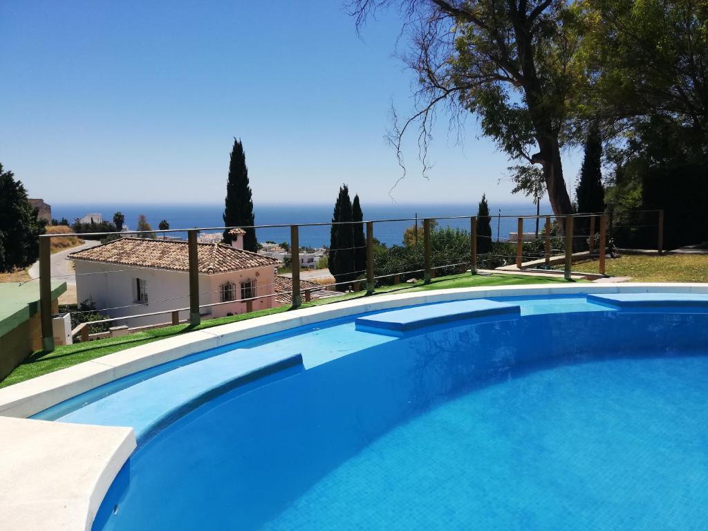 a blue swimming pool with a view of the ocean at Finca Villordo Villa Tranquila in Benalmádena