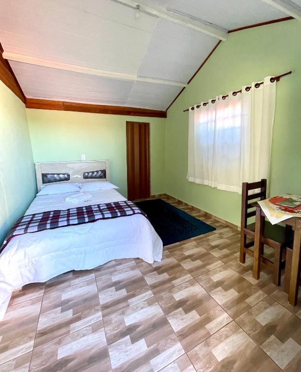 a bedroom with a large bed and a table at Cantinho de Serra in Cunha