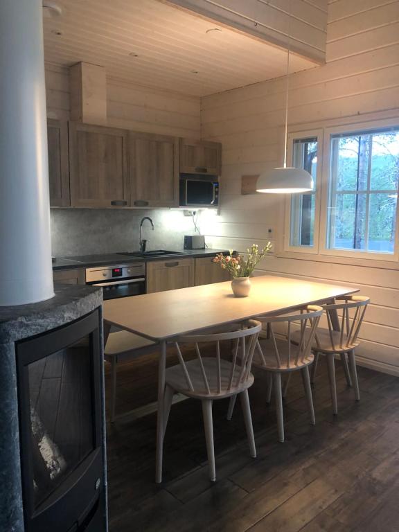 a kitchen with a wooden table with chairs and a television at Ylläs Fell Inn in Äkäslompolo