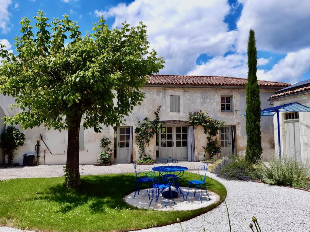 uma mesa e cadeiras em frente a uma casa em Gîte des oiseaux em Préchac