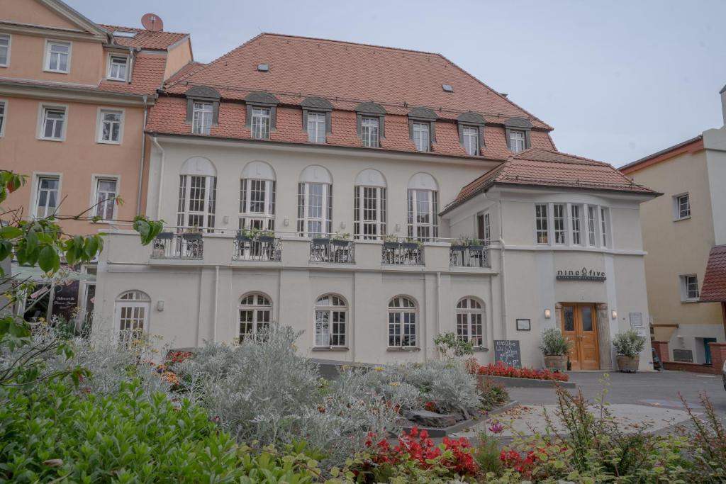 un gran edificio blanco con techo rojo en Nineofive Hotel en Jena