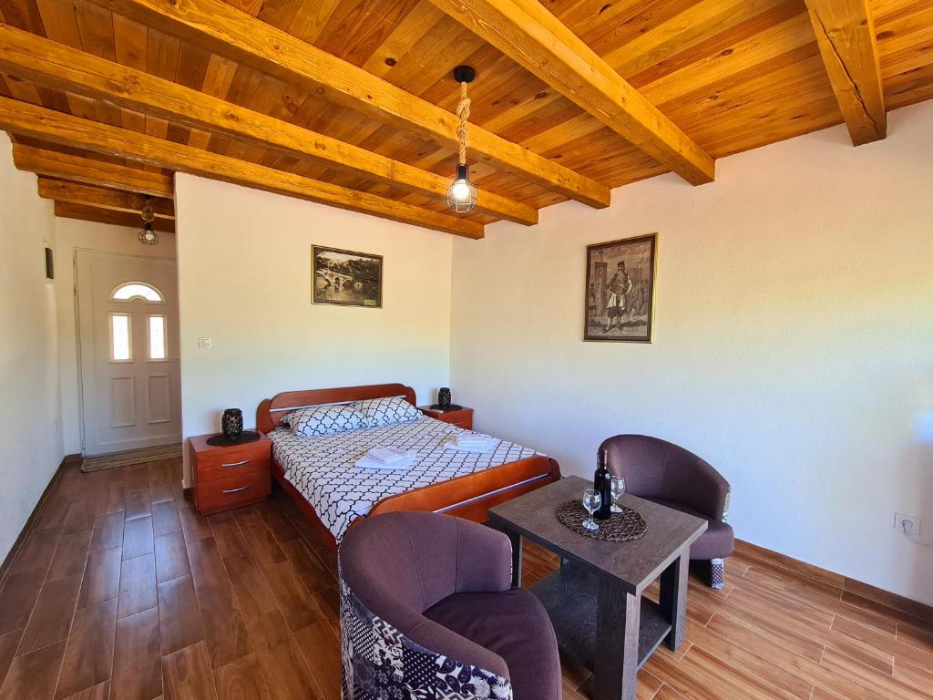1 dormitorio con 1 cama, mesa y sillas en S&M Apartments en Rijeka Crnojevića