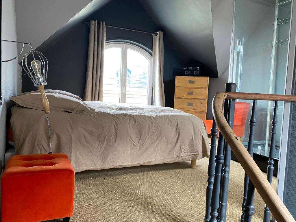 une chambre avec un lit et une fenêtre dans l'établissement Gîte 1908 avec GARAGE, à Wimereux