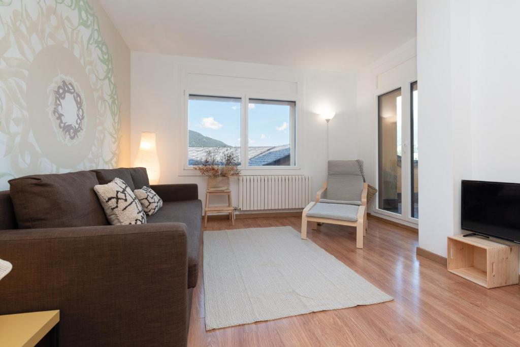 uma sala de estar com um sofá e uma televisão em Apartamento Fontargent 2 em Soldeu