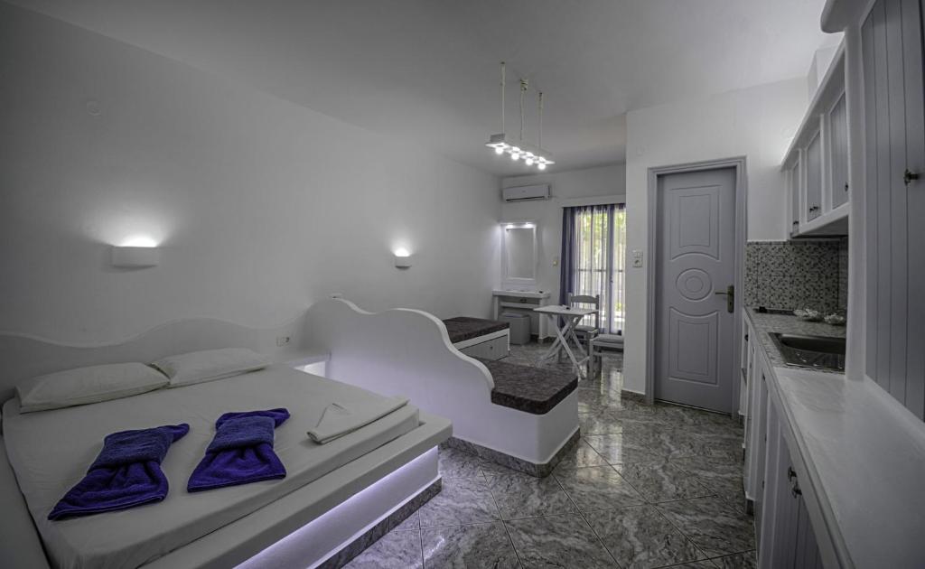 a bedroom with a white bed with blue pillows on it at Anerousses in Adamas