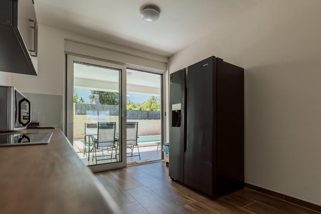 a kitchen with a large glass door leading to a patio at Villa Danijela in Malinska