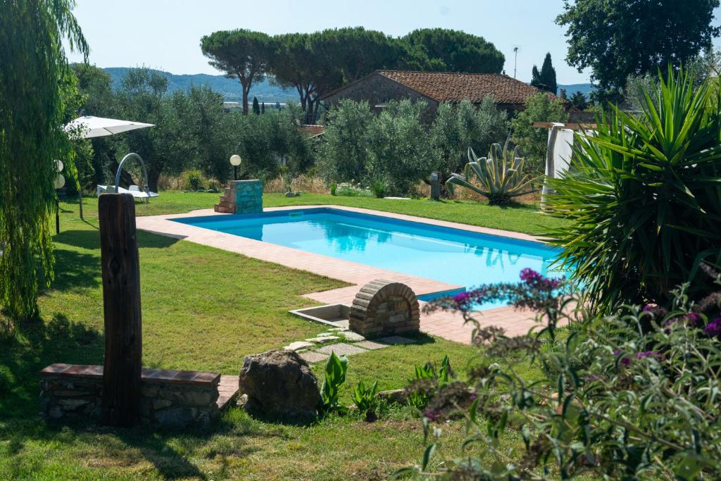 a swimming pool in a yard with a landscaping at Agriturismo Colle Vento in Suvereto