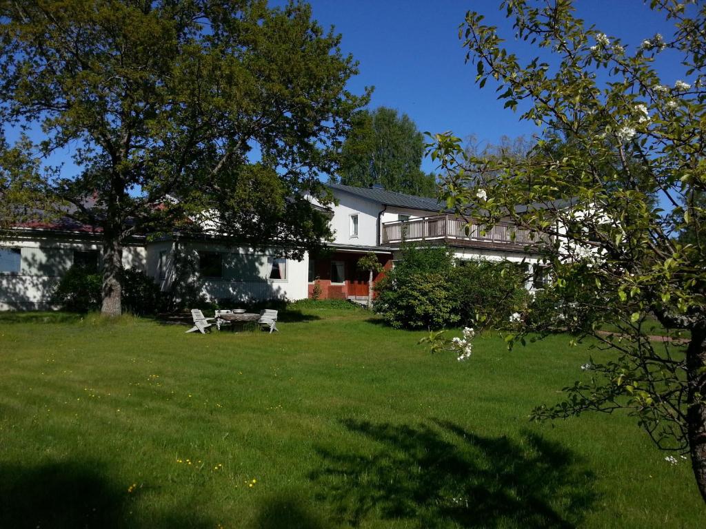 uma casa branca com um quintal com uma árvore em Havsbandet Pensionat em Eckerö