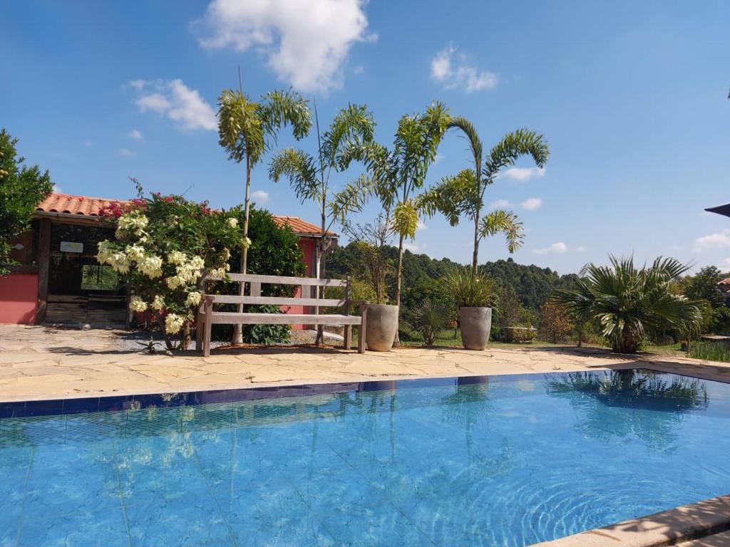 una panchina seduta accanto a una piscina di Pousada Portal da Serra a Carrancas