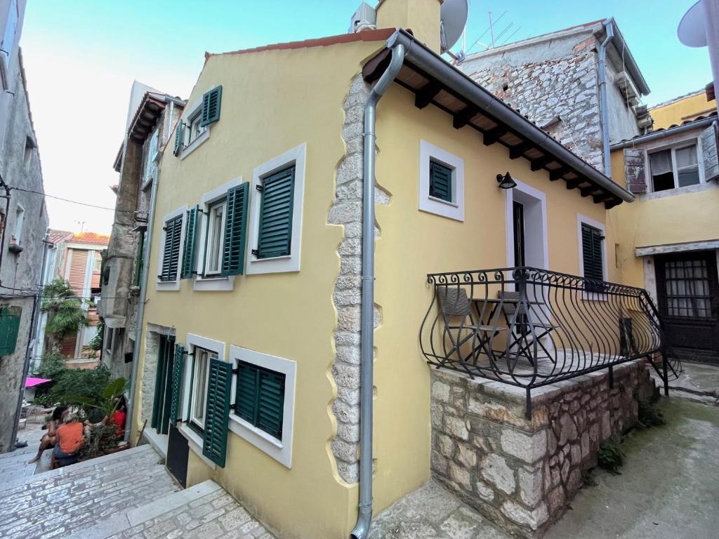 a yellow house with a balcony on a street at Yellow House Rovinj in Rovinj