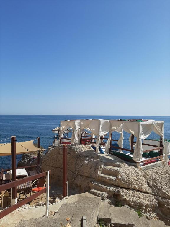 a group of umbrellas on a cliff near the ocean at Guesthouse DONA in Ulcinj