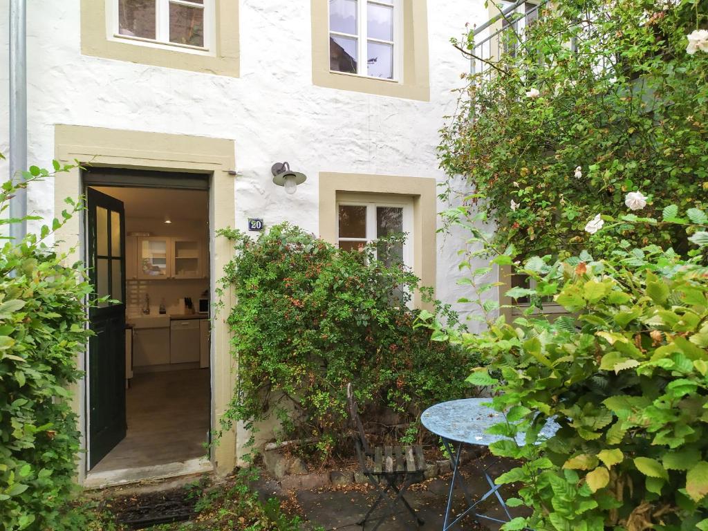 una casa blanca con una mesa delante en Living-in-History: Meister Carl Apartment, en Dudeldorf
