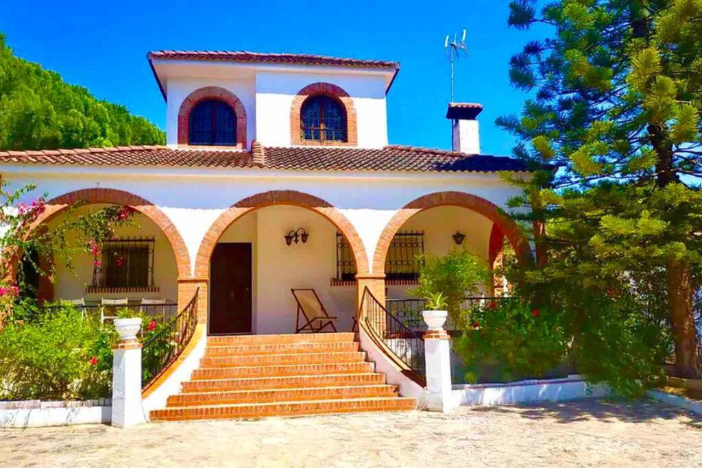 een huis met een trap ervoor bij Agradable casa de campo con piscina en la Barrosa in Chiclana de la Frontera