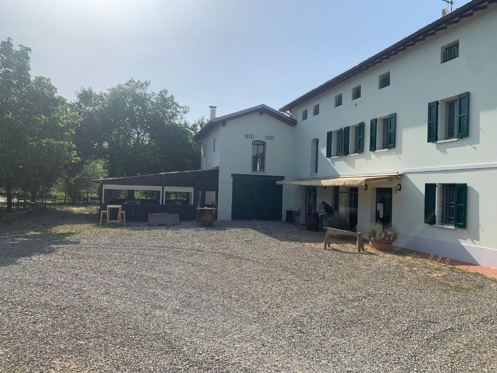 a large white house with a gravel yard next to it at Villa Canapa in Campogalliano