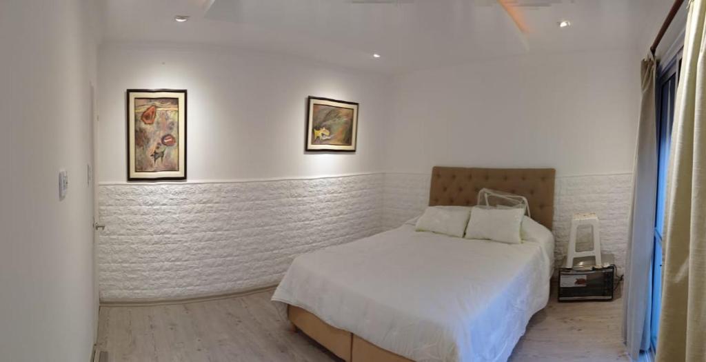 a bedroom with a bed and two pictures on the wall at Buona Notte! in Bahía Blanca