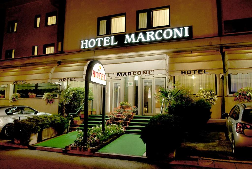 パドヴァにあるホテル マルコーニのホテルの前に緑の芝生があります。