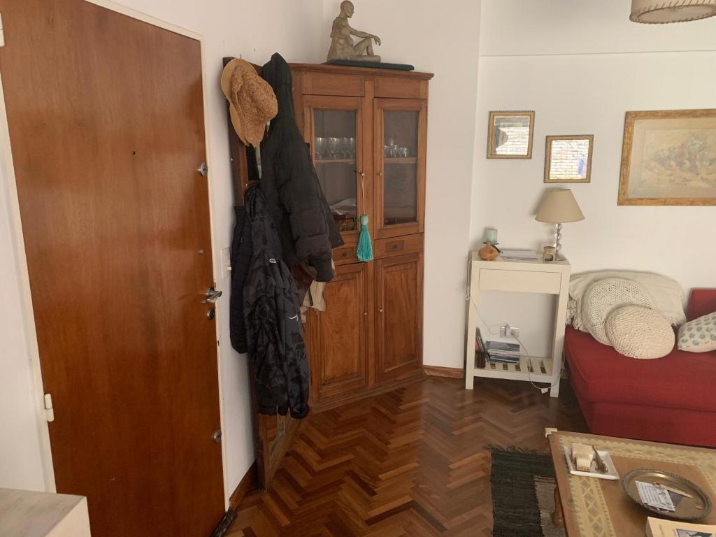 una habitación con puerta y una habitación con sofá rojo en excelete departamento en el centro de Martinez en Martínez