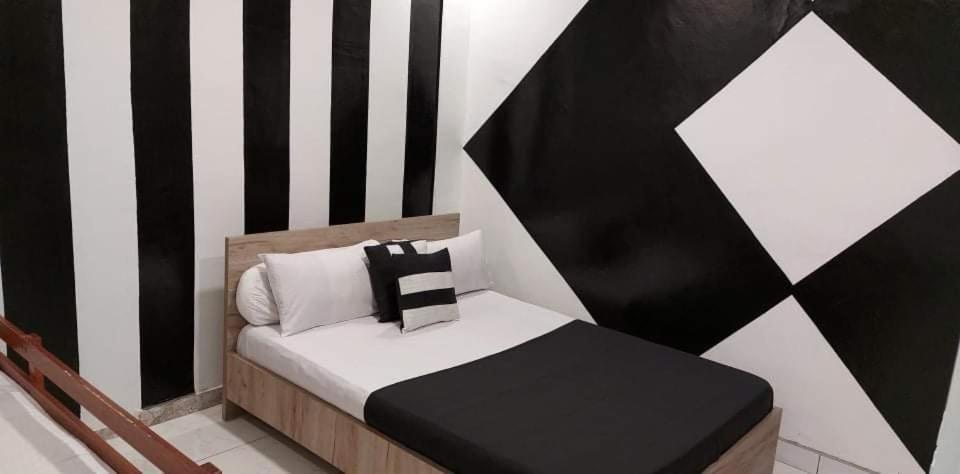 a small bedroom with a black and white striped wall at Auberge bouloulou in Bouéni