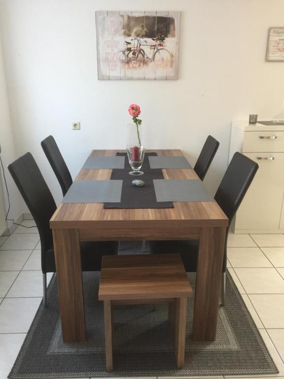 a wooden table with black chairs and a vase on it at Kraichgau-Nest in Reichartshausen