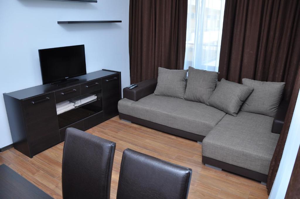 sala de estar con sofá y TV de pantalla plana en Mamaia Summerland Apartments, en Mamaia