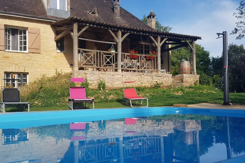 une maison avec une piscine en face d'une maison dans l'établissement Magnifique maison périgourdine avec piscine, à Sarlat-la-Canéda