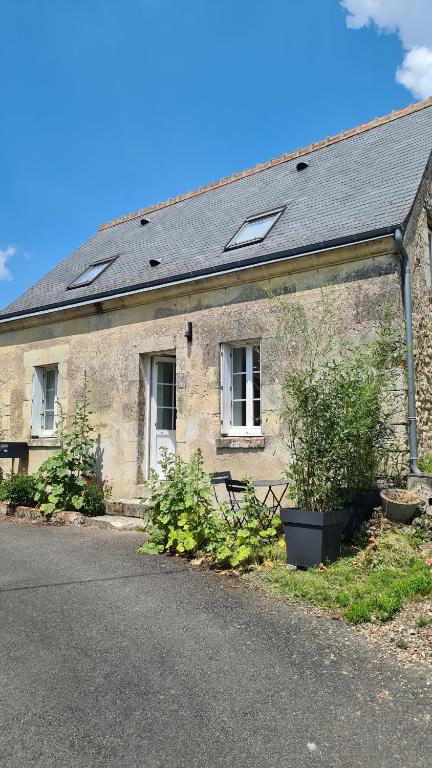 un bâtiment en pierre avec un banc devant lui dans l'établissement La Loge de Gabrielle, à Montlouis-sur-Loire