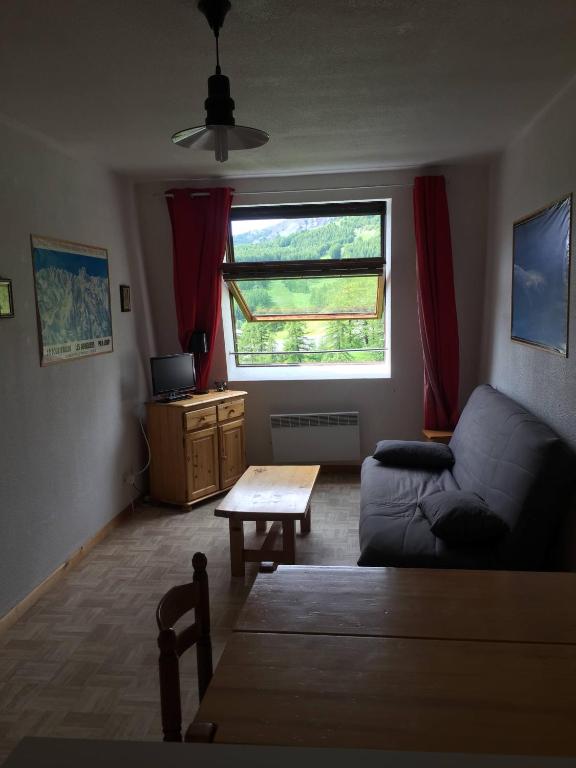 un salon avec un canapé et une table dans l'établissement Studio montagne, à Allos