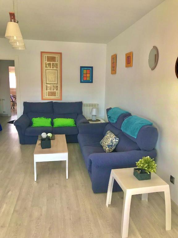 a living room with a blue couch and two tables at Galicia47 in Zamora