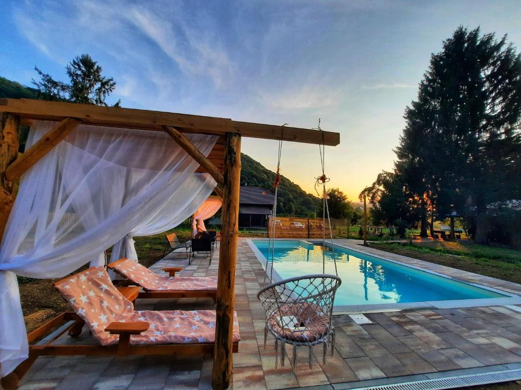 a patio with a swing and a swimming pool at Vacation House Studenac in Bihać